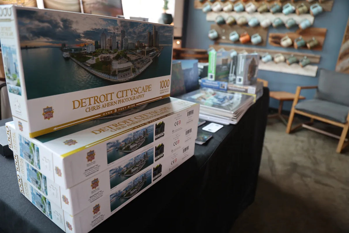 Puzzles with Detroit cityscape design on a table in a store setting